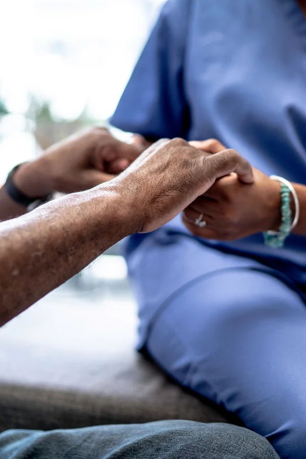 Infirmier qui tient les mains d'un patient à Charleroi - Jv Care